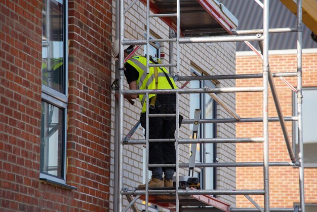 construction-workers-using-aluminium-mobile-scaffold-tower-safety-harness-work-height_245726-1737