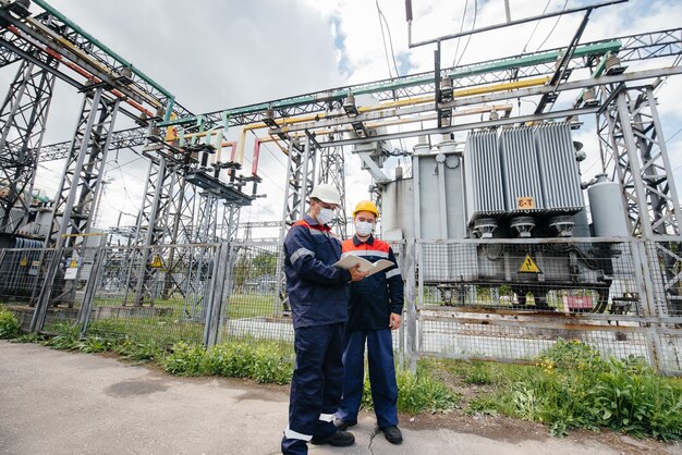 engineers-electrical-substations-conduct-survey-modern-high-voltage-equipment-mask-time-pandemia-energy-industry_180601-7084