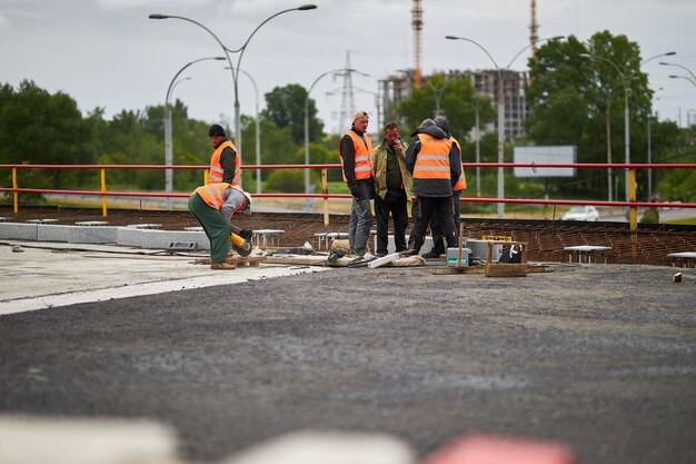 kyiv-ukraine-september-15-2020-road-workers-orange-vests-repair-road-surface_345343-6390