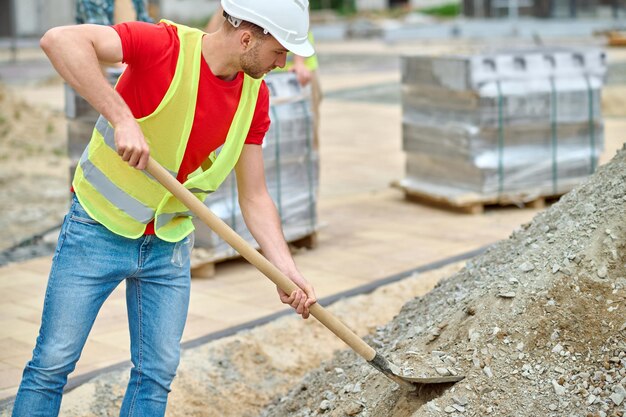 man-with-shovel-picking-up-rubble-construction-site_259150-57621