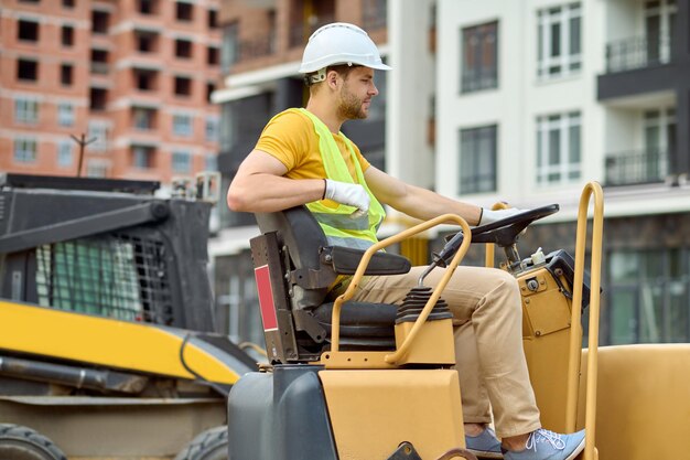 profile-man-sitting-wheel-excavator_259150-57636